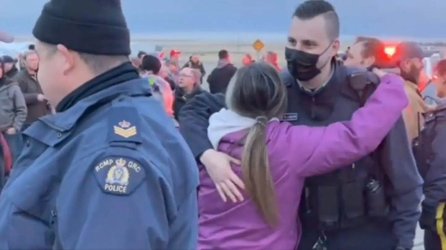 RCMP officers hug blockaders in Coutts, Alberta