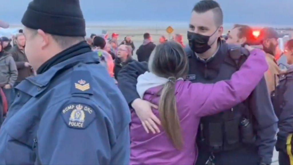 RCMP officers hug blockaders in Coutts, Alberta